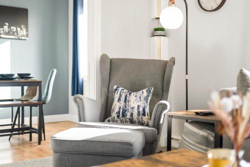 ein Wohnzimmer mit einem Stuhl und einem Tisch in der Unterkunft Stylish & Convenient 4BR House w/ Garden & Parking in Bournemouth