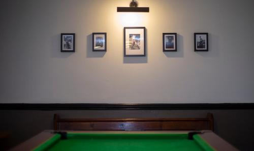 a pool table in a room with pictures on the wall at Redesdale Arms in Otterburn