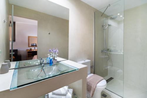 a bathroom with a glass sink and a shower at Thealos Village aparthotel Lefkada in Lygia