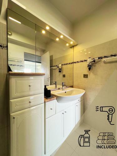 une salle de bain avec un lavabo et un miroir dans l'établissement Le Best View, Climatisé vue mer panoramique, Parking gratuit, WIFI, à Menton