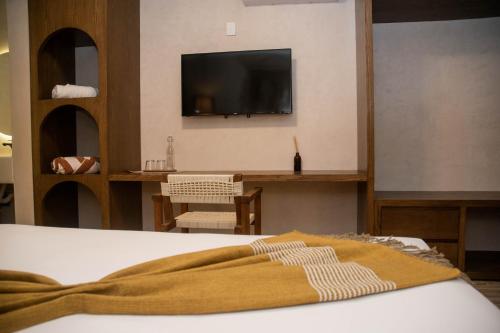 um quarto com uma cama e uma televisão na parede em Eterna Tulum em Tulum