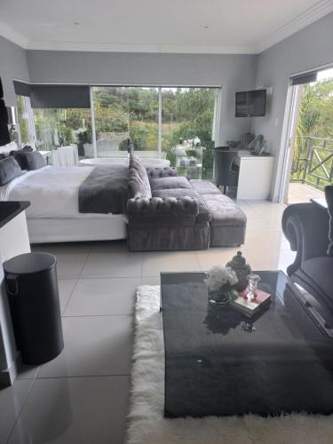 a bedroom with a bed and a couch and a table at North Haven Country Estate in Honeydew