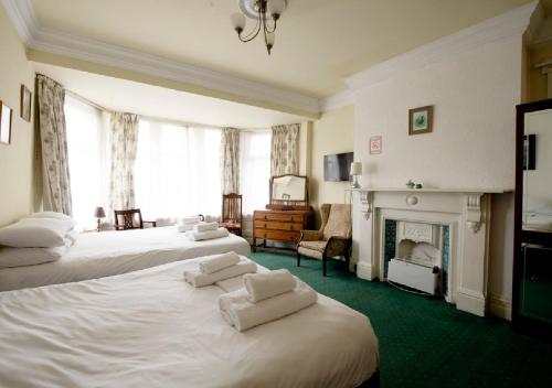 een hotelkamer met 2 bedden en een open haard bij Hotels 24-7 - The Old Victoria Hotel in Newport