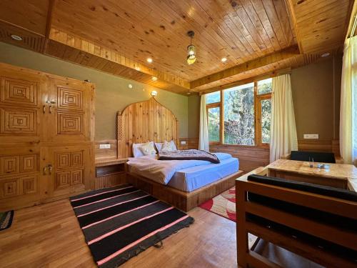 a bedroom with a bed and a wooden ceiling at The Village View Homestay in Jibhi