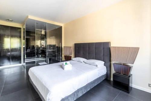 - une chambre avec un grand lit blanc et des murs en verre dans l'établissement HSH Lamballe-Passy Magnifique Appartement 4P, à Paris