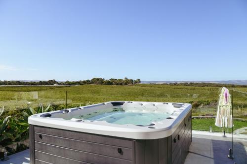 una bañera de hidromasaje en un patio con vistas a un campo en Miravino – breathtaking vineyard views en McLaren Vale
