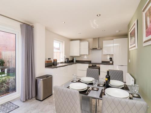 a kitchen with a table and chairs and a kitchen with white cabinets at Derwent House in Pickering