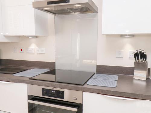 a kitchen with white cabinets and a counter top at Derwent House in Pickering