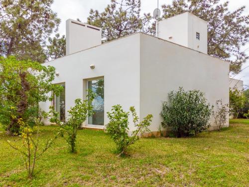 a white house with trees in front of it at Casa Levante by HelloVacations in Tavira
