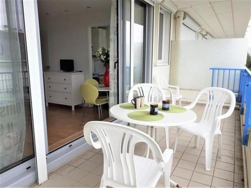 une table blanche et des chaises sur un balcon dans l'établissement Studio au pied de la plage à La Baule avec balcon et toutes commodités! - FR-1-392-158, à La Baule