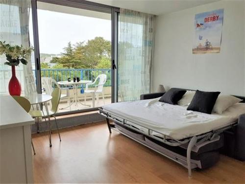 une chambre avec un lit et un balcon avec une table dans l'établissement Studio au pied de la plage à La Baule avec balcon et toutes commodités! - FR-1-392-158, à La Baule