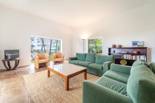 a living room with green couches and a coffee table at Casa Levante by HelloVacations in Tavira