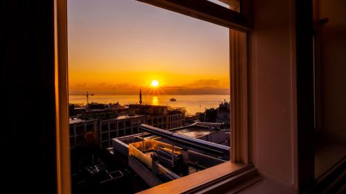 einen Blick auf den Sonnenuntergang von einem Fenster aus in der Unterkunft Loop Hotel Bosphorus İstanbul in Istanbul