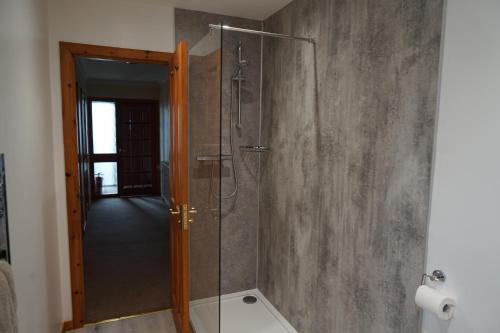 a shower with a glass door in a bathroom at Maybank in Fort William