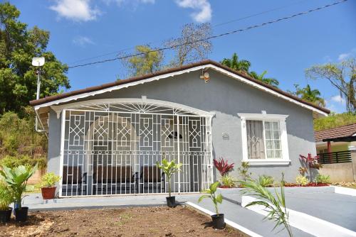 a house with a gate in front of it at The West Village Summer House - Montego Bay in Montego Bay