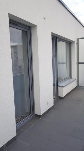 three windows on the side of a white building at Posnania Comfort Apartment, free parking, self check-in 24h in Poznań