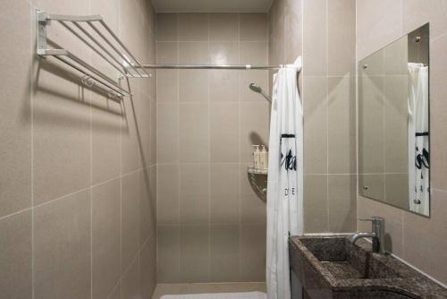 W łazience znajduje się prysznic i umywalka. w obiekcie WESU Weisu Executive Apartment Shenzhen Shenda Metro Store w mieście Shenzhen