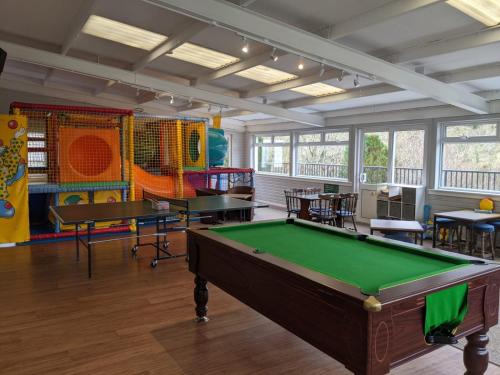 a room with a pool table and some tables at Corriefodly Holiday Park in Blairgowrie