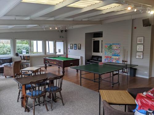 a living room with two ping pong tables and chairs at Corriefodly Holiday Park in Blairgowrie