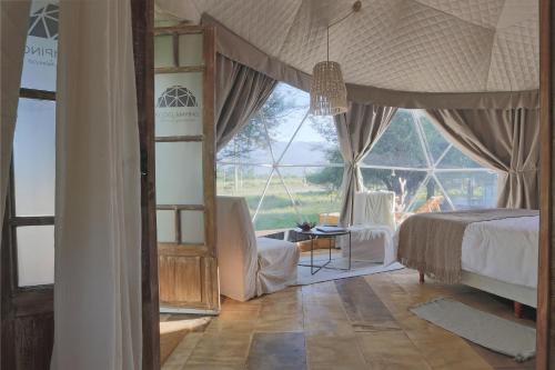 a bedroom with a bed and a large window at Glamping Tafí del valle in Tafí del Valle