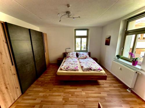 ein Schlafzimmer mit einem Bett in der Mitte des Zimmers in der Unterkunft Fewo Klöppel Auersbergblick in Eibenstock