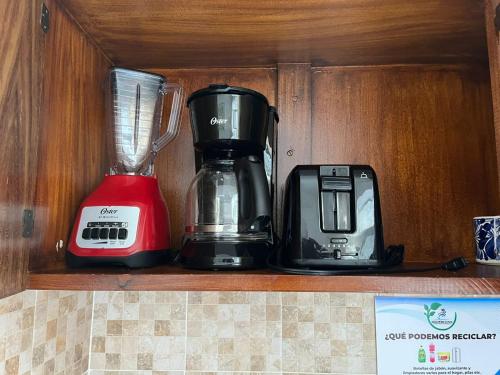 dois aparelhos sentados numa prateleira numa cozinha em Departamento familiar con vista al mar em Manzanillo