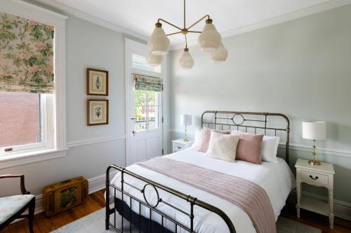 a bedroom with a bed with pink pillows and a window at The Boulevard Inn in Richmond
