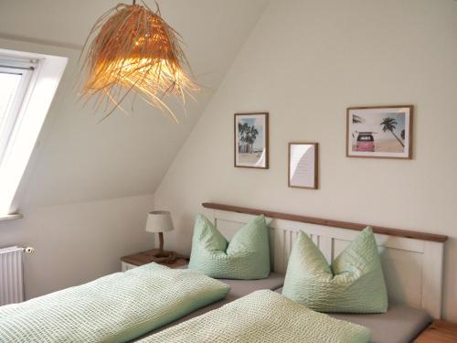 比蘇姆的住宿－Surf Bude，一间卧室配有一张带绿色枕头的床