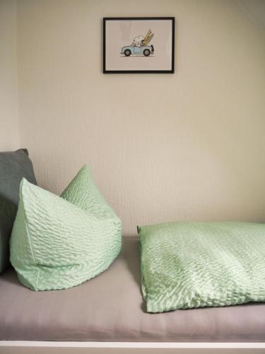 a couch with two pillows and a picture of a car at Surf Bude in Büsum