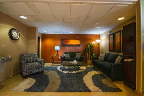 a lobby with two chairs and a couch and a rug at Travelodge by Wyndham Pueblo in Pueblo