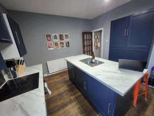 a kitchen with blue cabinets and a white counter top at House near restaurants, park and pubs, perfect for pets! in Bristol