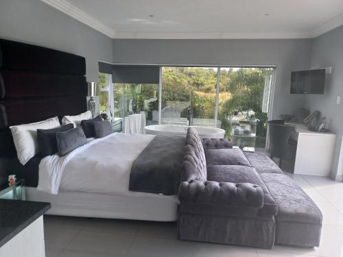 a large bedroom with a large bed and a couch at North Haven Country Estate in Honeydew