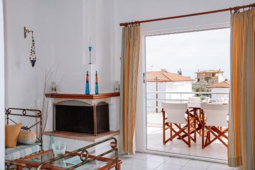 a living room with a fireplace and a sliding glass door at Dimitra's Sunset View Apartment in Kalivia Poligirou