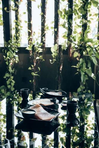 a table with bowls and cups on it with plants at Retrieve Health & Wellness in Cochin