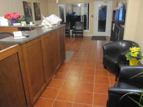 a waiting room with a reception desk and chairs at Sandy Beach Suites in Osoyoos