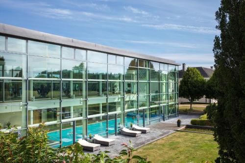 a large glass building with a swimming pool at Castlemartyr Resort Hotel in Castlemartyr