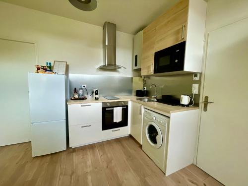 eine kleine Küche mit einem Kühlschrank und einer Waschmaschine in der Unterkunft Le Yellow Peak - Centre Ville - Maison Boucicaut - BY PRIMO C0NCIERGERIE in Chalon-sur-Saône
