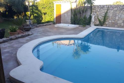 a swimming pool in a backyard with blue water at VILLA CARMEN in Alcossebre