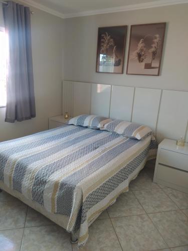 a bedroom with a large bed with two pillows at imóvel ideal para suas férias em Canto Grande in Bombinhas