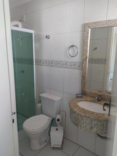 Un baño con inodoro, lavabo y espejo. en imóvel ideal para suas férias em Canto Grande, en Bombinhas