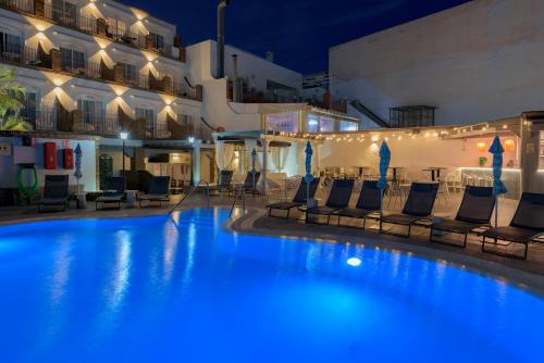 ein großer Pool mit Stühlen und ein Gebäude in der Unterkunft Hotel Boutique Sibarys - Adults Recommended in Nerja