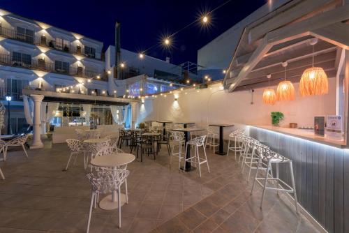 a restaurant with tables and chairs and lights at Hotel Boutique Sibarys - Adults Recommended in Nerja