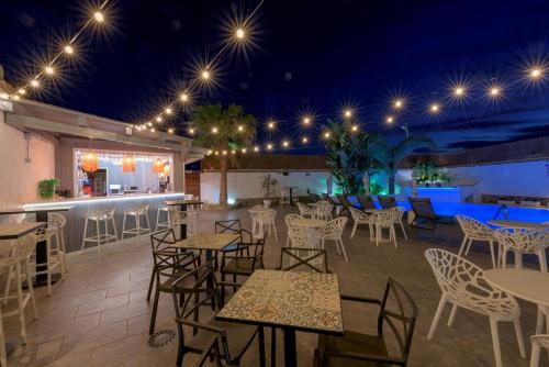 a patio with tables and chairs and a bar at Hotel Boutique Sibarys - Adults Recommended in Nerja