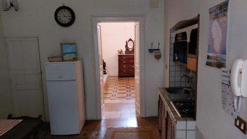 a kitchen with a refrigerator and a clock on the wall at Antica Via delle Aie in Ruffano