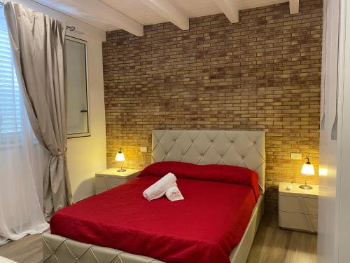 una camera con letto rosso e parete in mattoni di Villa Milisa a Terrasini