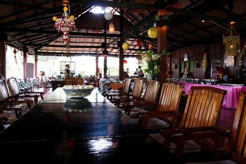 ein Esszimmer mit einem langen Tisch und Stühlen in der Unterkunft The Emerald Krabi Beach Resort in Klong Muang Beach