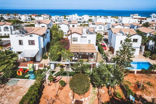 an aerial view of a neighborhood with white houses and the ocean at SunnyVillas: 4BR Villa☆Private Pool + Jacuzzi - Villa Amelie in Protaras