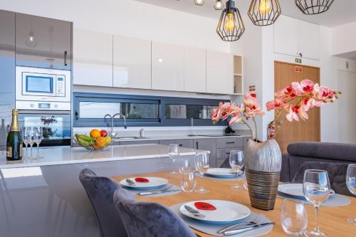 a kitchen with a table with a vase of flowers at Villa Plumeria in Arco da Calheta