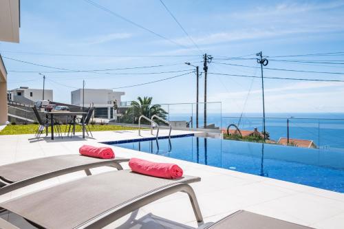 a swimming pool with a view of the ocean at Villa Plumeria in Arco da Calheta