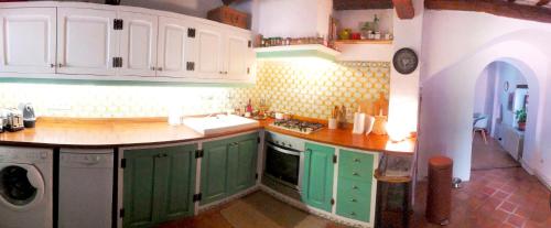 - une cuisine avec des placards verts et un lave-linge dans l'établissement Palou 1900 Garraf, à Sant Pere de Ribes
